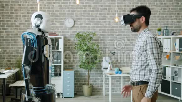 办公室虚拟现实眼镜中年轻科学家的机器人模仿动作视频的预览图