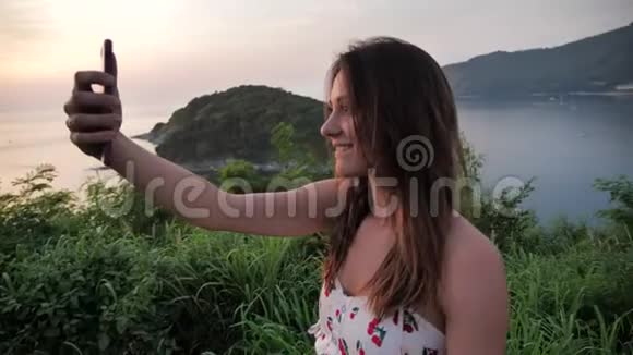 在美丽的景观背景上特写迷人的女人的肖像女性在山顶拍摄日落视频的预览图