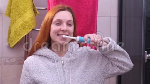 浴室里的女人用电动牙刷刷牙视频的预览图