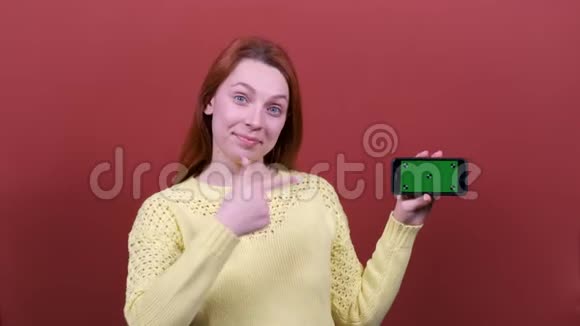 红头发的女人拿着空的色度手机人真诚的情感生活方式的观念视频的预览图