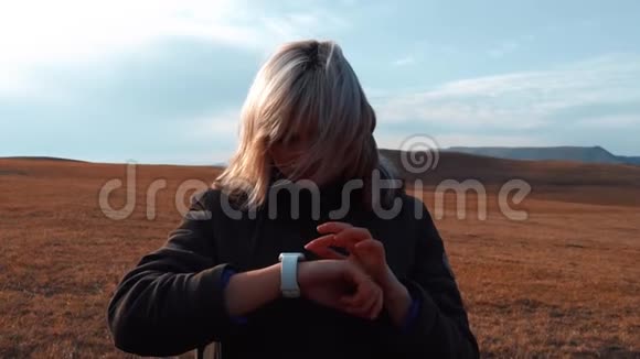 年轻女孩在山上用一只智能手表视频的预览图