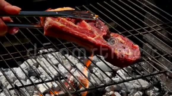肉排和肉钳放在烤架上视频的预览图