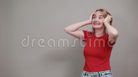 尖叫的年轻女子抬起头双手放在被隔离在黄墙上的头上视频的预览图