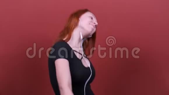 红头发的女人用耳机听音乐和跳舞人真诚的情感生活方式的观念视频的预览图