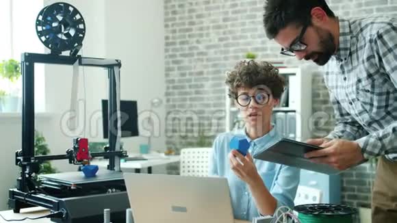 工程师女孩和男孩在办公室讨论使用平板电脑的3D打印模型视频的预览图