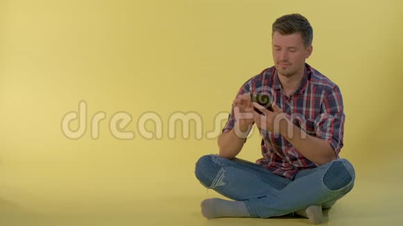 帅哥坐在地板上和朋友在智能手机上聊天视频的预览图
