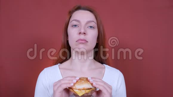 女人在红色背景下吃汉堡包快餐食品视频的预览图