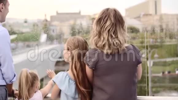 幸福的家庭享受从俯瞰的人行桥风景站在他们的背部视频的预览图