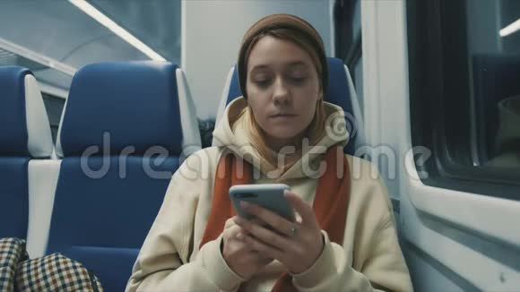 火车上迷人的微笑女孩用智能手机与朋友聊天的照片女性手部互联网技术手机城市m视频的预览图