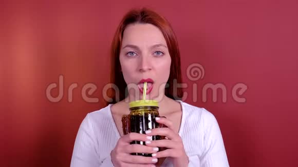 美丽的少女通过仙人掌杯喝软饮料视频的预览图