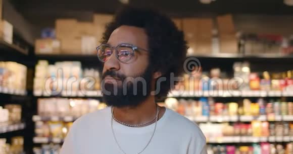 一个戴眼镜的帅哥在超市里走来走去30多岁的成熟男人在寻找产品视频的预览图