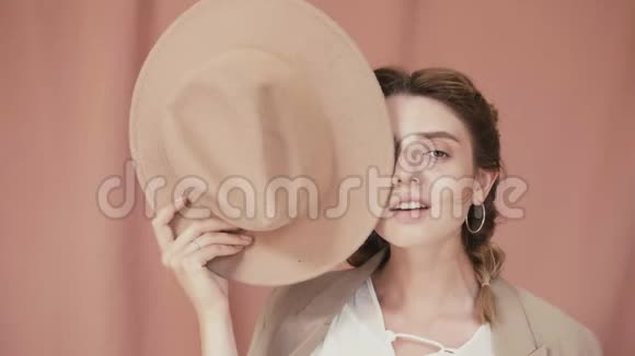 肖像女时尚粉红色有乐趣的微笑在工作室与粉红色背景慢动作instagram模特博主视频的预览图
