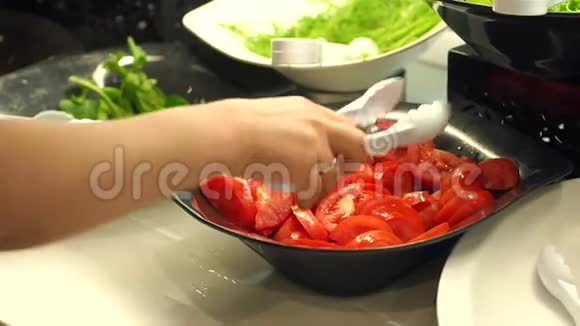 一个带钳子的女孩的特写需要一个切片的西红柿提供餐饮自助餐视频的预览图