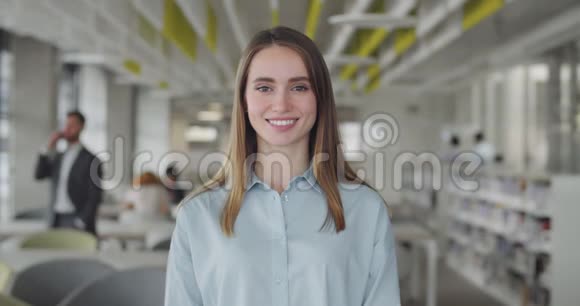 微笑的白种人女实习生站在现代办公空间年轻女性办公室经理的肖像视频的预览图