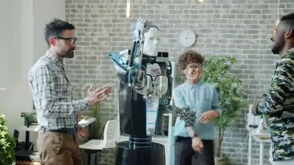 快乐的机器人工程师在办公室里和智能的人类机器人跳舞视频的预览图