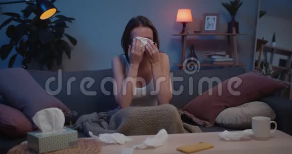 年轻不幸的千禧一代女性哭泣并使用纸组织绝望的女人泪流满面地坐在沙发上视频的预览图
