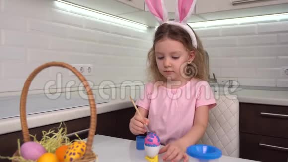 复活节快乐小女孩画复活节彩蛋为复活节做准备的快乐家庭孩子可爱的小女孩视频的预览图