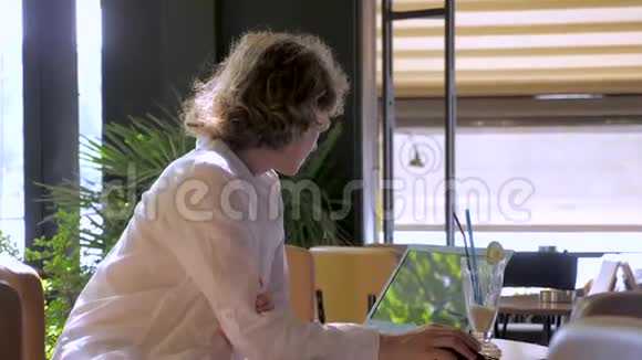 年轻的城市数码女性千禧一代z岁坐在度假胜地或旅游度假目的地在笔记本电脑上工作视频的预览图