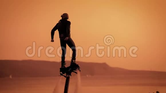 在日落时分男性外在海上飞板用脚引导木板特写人物形象视频的预览图