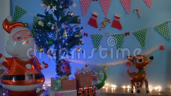 年轻漂亮的女孩坐在五颜六色的圣诞树下打开礼物盒视频的预览图