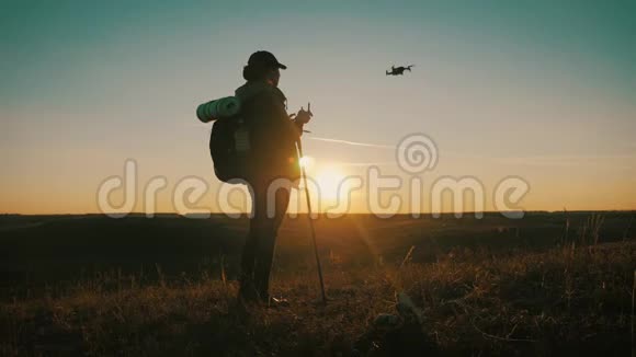 女游客在旅途中驾驶飞机日落时分在山上的旅行者的剪影视频的预览图