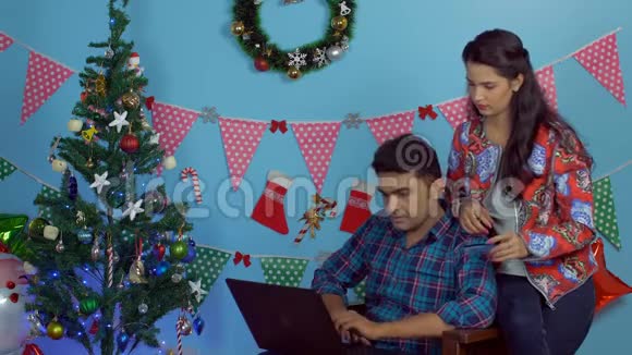 快乐的一对情侣用笔记本电脑和信用卡在网上购物视频的预览图