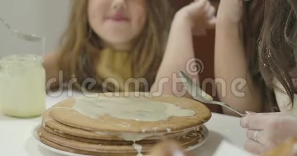 蛋糕上抹着炼乳站在桌子上小漂亮的女孩在后台吃加糖的牛奶可爱视频的预览图