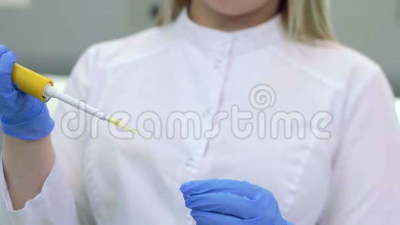 在医学或科学实验室中使用实验室吸管关闭科技的双手视频的预览图
