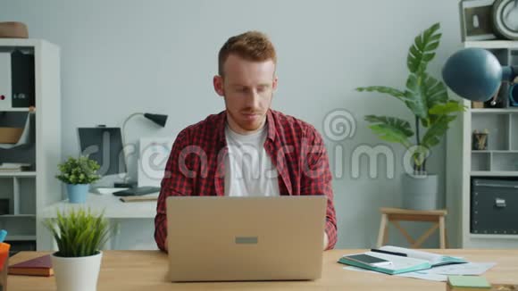 有魅力的家伙在办公室里用笔记本电脑打字专注于商业项目视频的预览图
