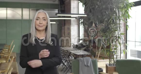 双手交叉站立的中年女商人的正面图穿着西装的漂亮女企业家视频的预览图