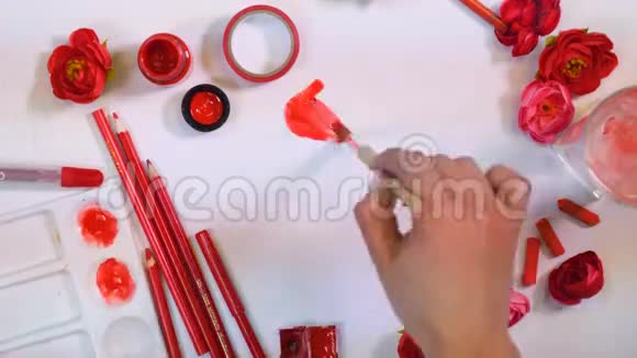 女艺人手画红花创意艺术家办公桌从上面视频的预览图