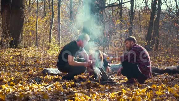 秋天森林里篝火的朋友视频的预览图