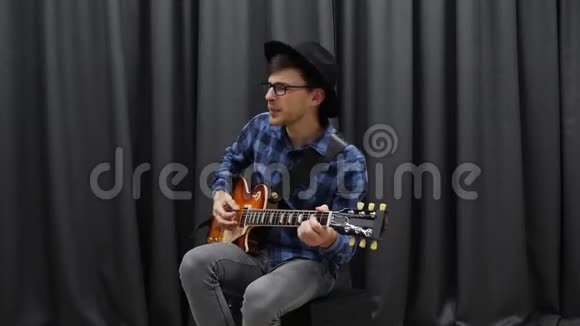 嬉皮男孩弹吉他唱歌年轻快乐的少年用电吉他弹唱乡村歌曲男子表演视频的预览图