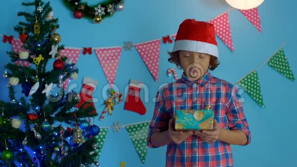 印度圣诞前夜戴着圣诞帽的可爱的小男孩提供了一个特别的礼品盒视频的预览图