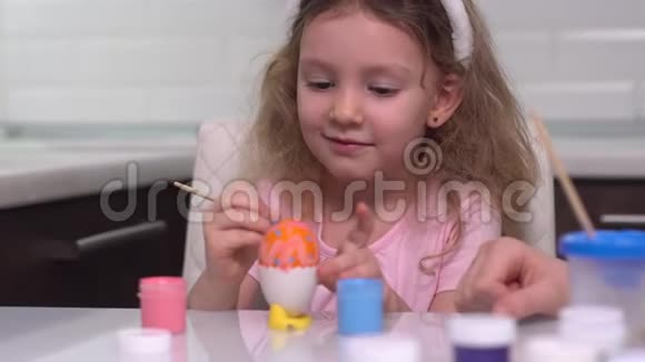 复活节快乐小女孩画复活节彩蛋为复活节做准备的快乐家庭孩子可爱的小女孩视频的预览图