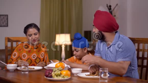 幸福的核心锡克族家庭包括一个小孩子一起在餐桌上吃饭家庭概念视频的预览图