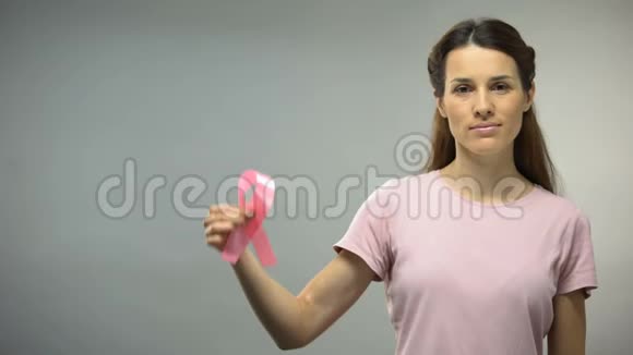 在镜头中展示粉红色丝带的女人国际乳腺癌意识视频的预览图