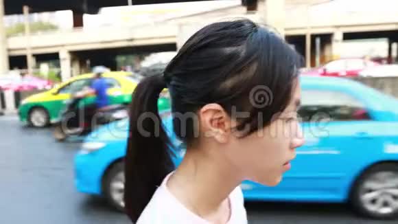 患病的亚洲女孩在城市大街上户外散步时双手打喷嚏妇女患有过敏性鼻炎PM25空气污染视频的预览图