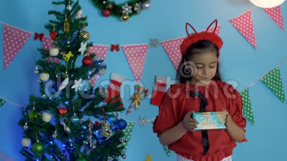 快乐的印度小女孩献上圣诞礼物脸上挂着灿烂的笑容休闲冬装视频的预览图
