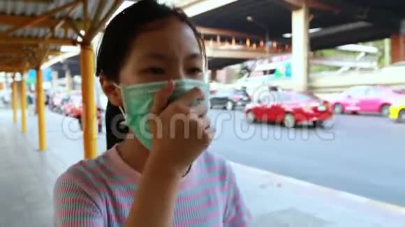 生病的亚洲女孩在曼谷的公共汽车站戴着防止空气污染的防护面具吸入细尘下午25女性视频的预览图