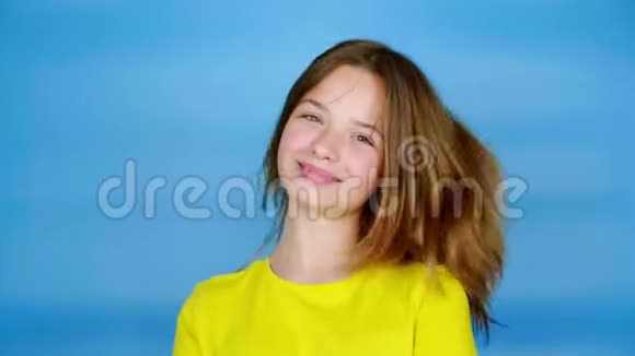穿黄色T恤的快乐少女转向镜头微笑视频的预览图