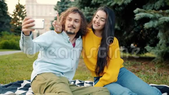 有趣的年轻夫妇在城市公园户外自拍的肖像视频的预览图