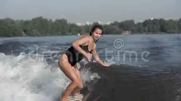 欧洲年轻的女运动员在河上拖着波浪在船后冲浪视频的预览图