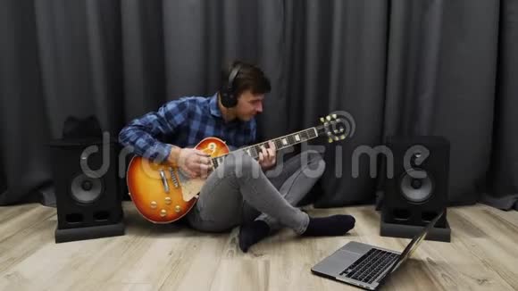 戴耳机的人弹吉他年轻的吉他手用电吉他演奏这首歌并喜欢演奏快乐的微笑视频的预览图