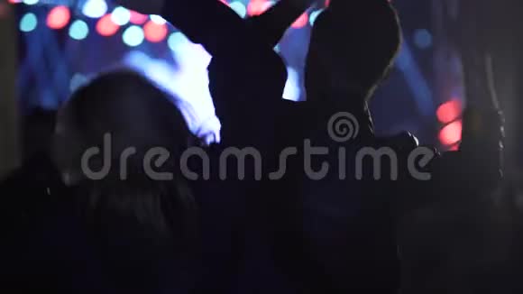 快乐的女人和男人在音乐节上挥舞双手跳舞夜生活视频的预览图