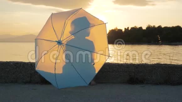 56岁的快乐男孩手里拿着雨伞沿着海岸线散步快乐男孩撑伞的肖像视频的预览图