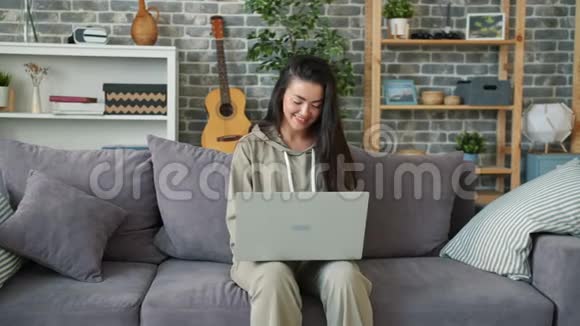 女自由职业者在客厅沙发上用笔记本电脑上网视频的预览图