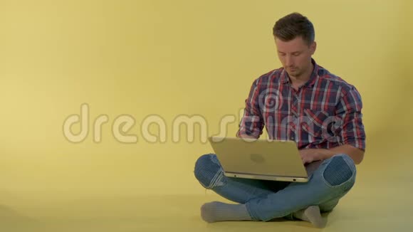 漂亮的年轻人坐在地板上和朋友在电脑上聊天视频的预览图