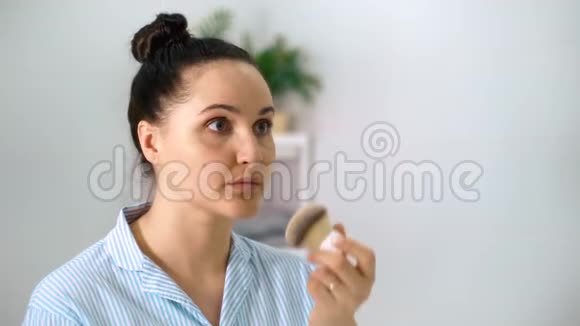 闭合年轻漂亮的女孩在浴室里用垫子抹粉视频的预览图