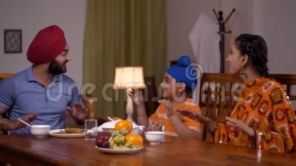 快乐的亚洲家庭在午餐桌上享受愉快地唱歌锡克族印第安人家庭视频的预览图